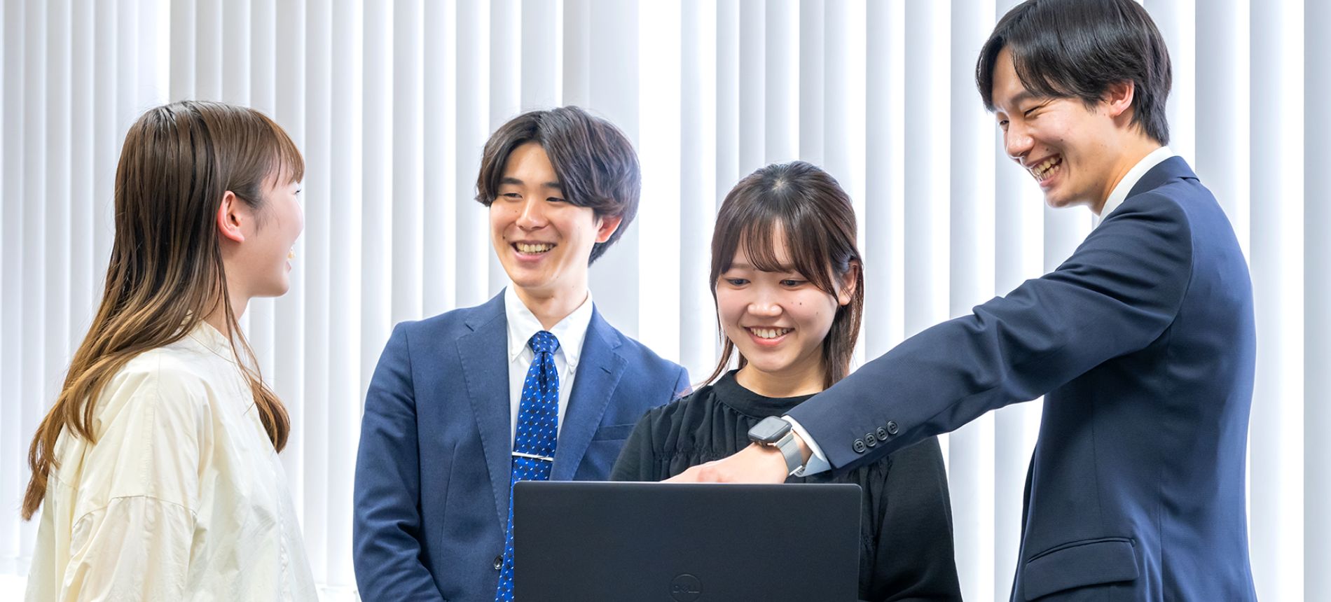 イメージ画像:4人の若い男女がパソコンを囲んで話し合っている画像
